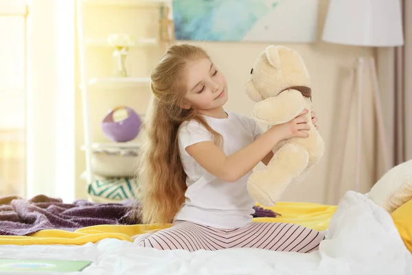 Маленька дівчинка, граючи з плюшевого ведмедика — стокове фото