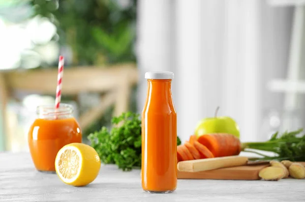 Банка и бутылка свежего морковного сока — стоковое фото