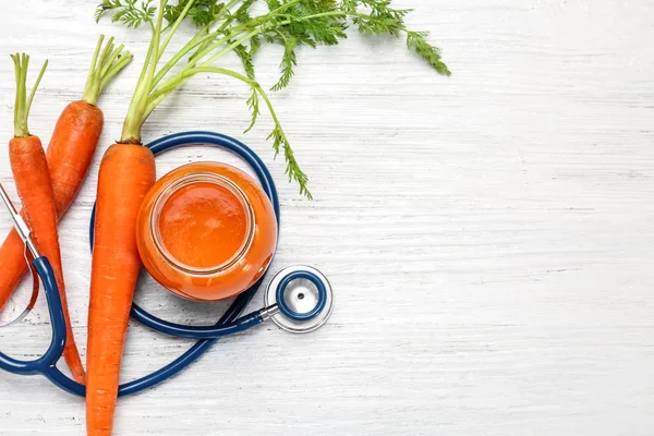 Pot en verre de jus de carotte avec stéthoscope — Photo