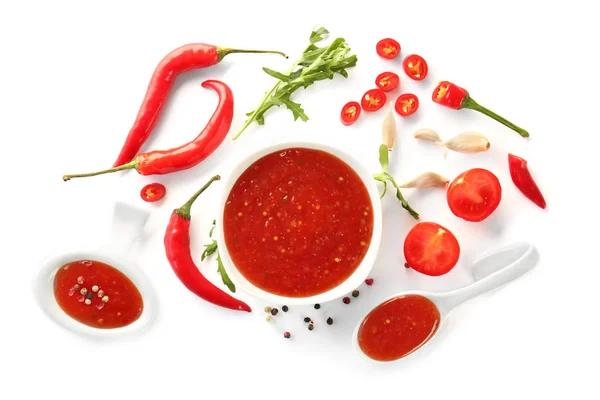 Gustosa salsa di peperoncino in ciotola e ingredienti su sfondo bianco — Foto Stock