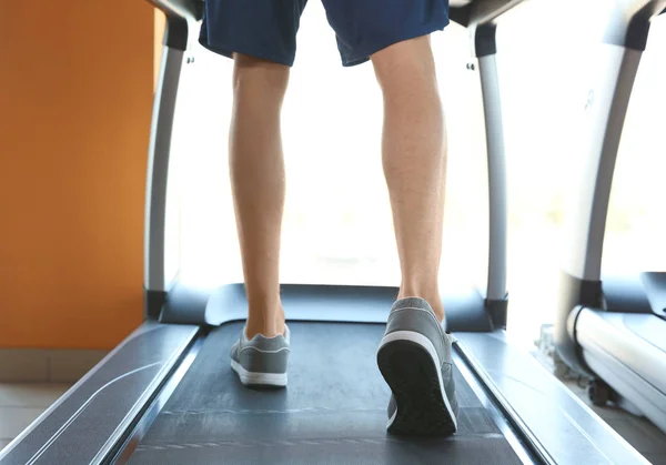 男人在健身房的跑步机训练腿 — 图库照片