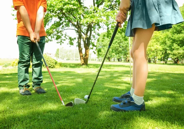 Lindos niños jugando al golf en el campo en un día soleado — Foto de Stock