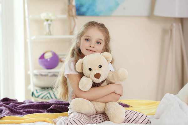 Small girl playing with teddy bear 