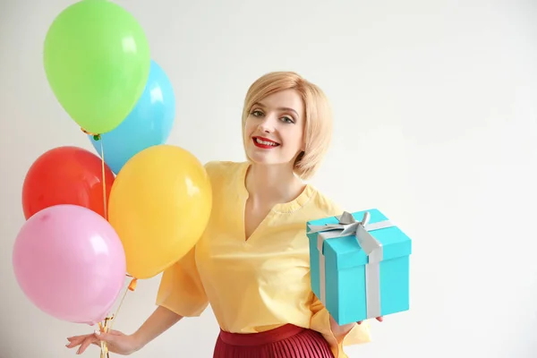 気球と白い背景の上のギフト ボックスを持った美しい女性 — ストック写真