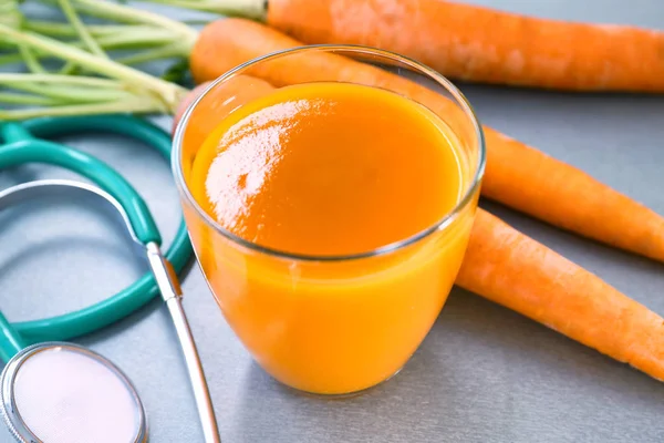 Succo con carota e stetoscopio — Foto Stock