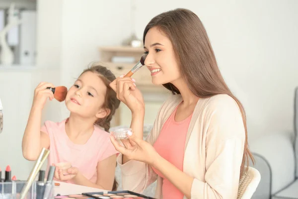 Kvinna och lilla dotter tillämpa makeup — Stockfoto