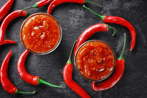 Gustosa salsa di peperoncino in ciotole sul tavolo — Foto Stock