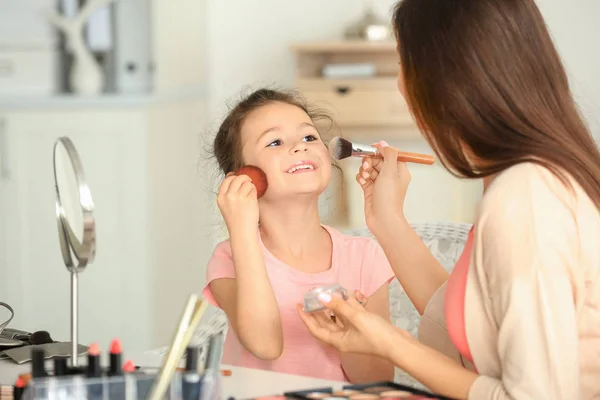 Mujer e hija pequeña aplicando maquillaje — Foto de Stock