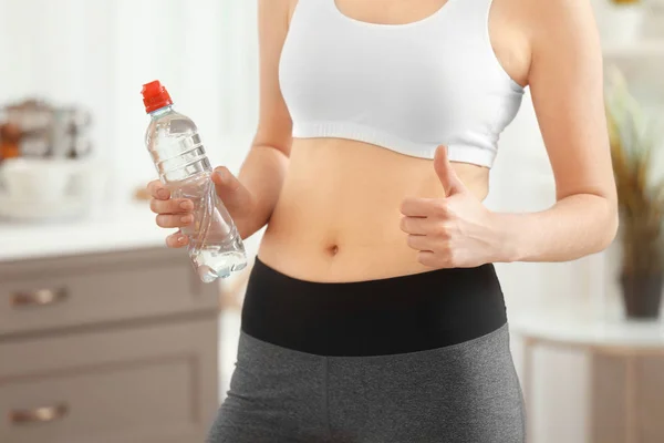 Woman with bottle of water at home, — Stock Photo, Image