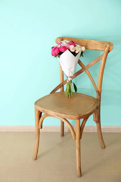 Ramo de hermosas flores de peonía en la silla en la habitación — Foto de Stock