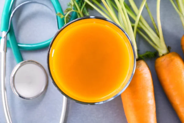 Succo con carota e stetoscopio — Foto Stock