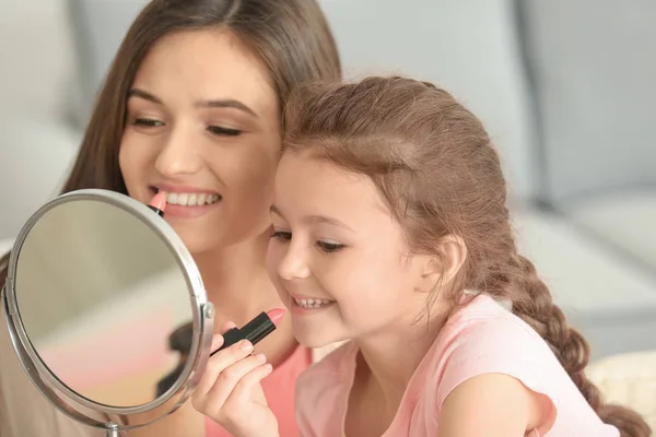 Mulher e filhinha aplicando maquiagem — Fotografia de Stock