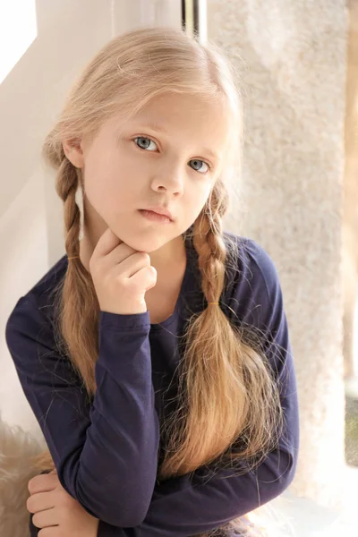 Cute little girl near window at home — Stock Photo, Image