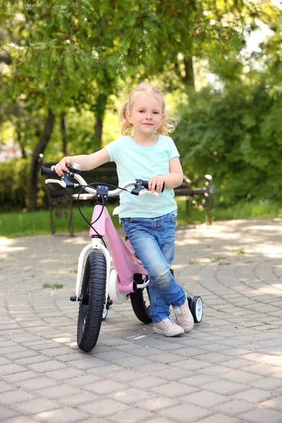 晴れた日に公園で自転車とかわいい女の子 — ストック写真