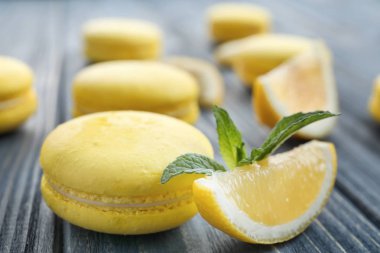 Lezzetli taze macaron ve limon dilim üzerinde ahşap masa, portre