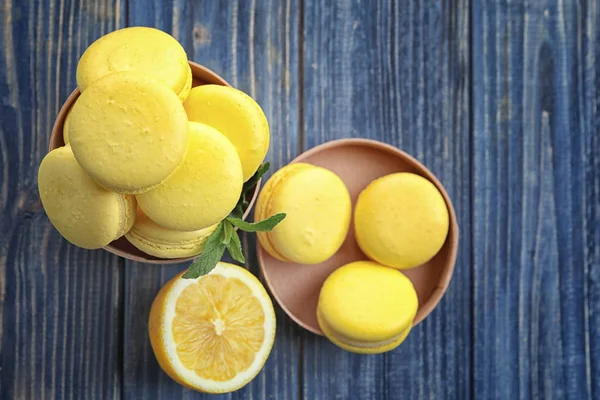 Boîte avec de savoureux macarons au citron sur table en bois — Photo