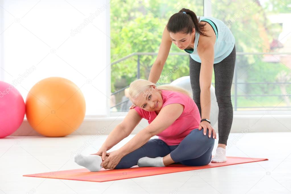 Instructor helping senior woman