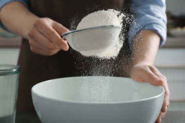 sifting flour into ceramic bowl clipart