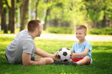 Baba oğul futbol topuyla oynuyorlar. 