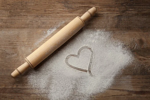 Heart drawn on flour and rolling pin — Stock Photo, Image