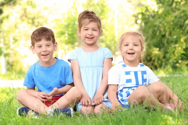 Kinderen zittend op gras — Stockfoto