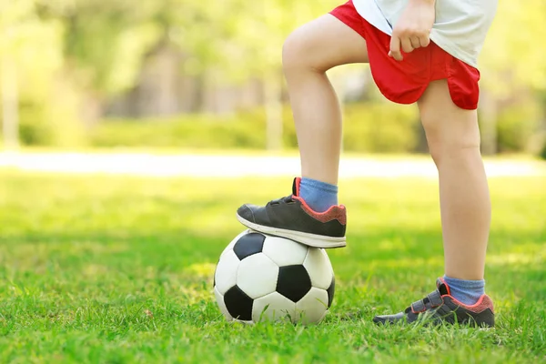 Ноги маленького мальчика с футбольным мячом — стоковое фото