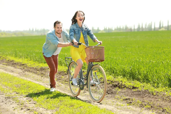 Hombre enseñando novia a montar en bicicleta — Foto de Stock