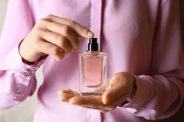 Manos sosteniendo frasco de perfume — Foto de Stock