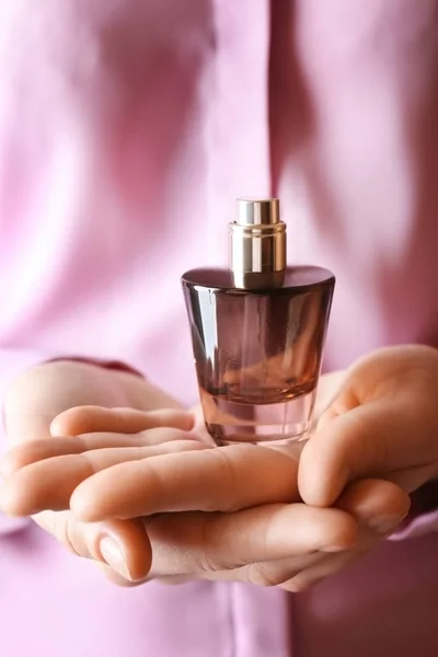Руки, що тримають пляшку парфумів — стокове фото