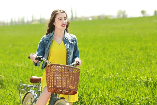 Mujer joven con bicicleta — Foto de Stock