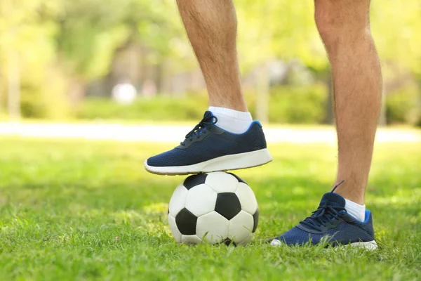 Pernas de homem jovem com bola de futebol — Fotografia de Stock