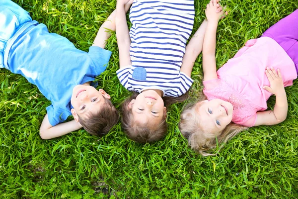 Kinderen liggen op gras — Stockfoto