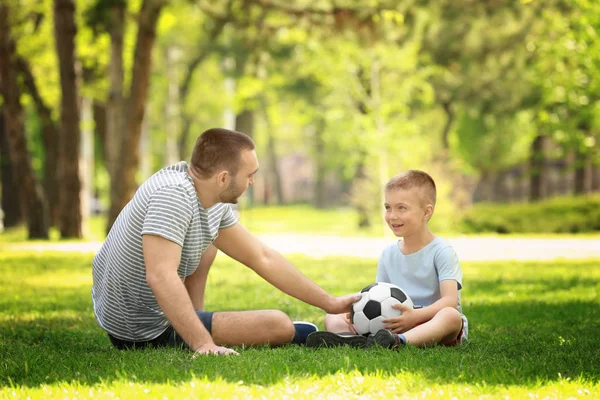 Baba oğul futbol topuyla oynuyorlar. 