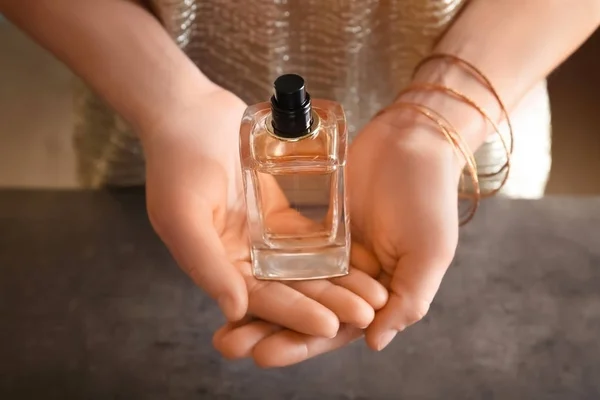 Ruce držící parfémy láhev — Stock fotografie