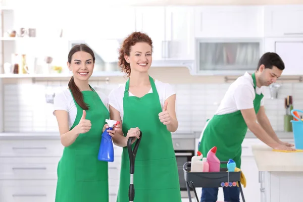 Команда уборщиков работает на кухне — стоковое фото