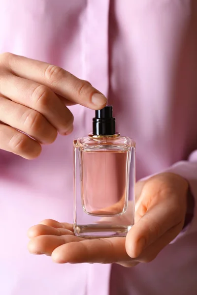 Ręce, trzymając butelkę perfum — Zdjęcie stockowe