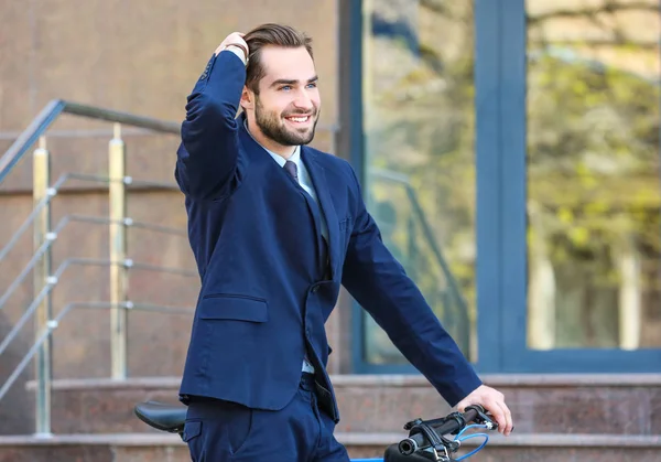 Joven hombre de negocios con bicicleta — Foto de Stock