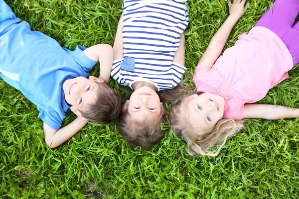 Kinderen liggen op gras — Stockfoto