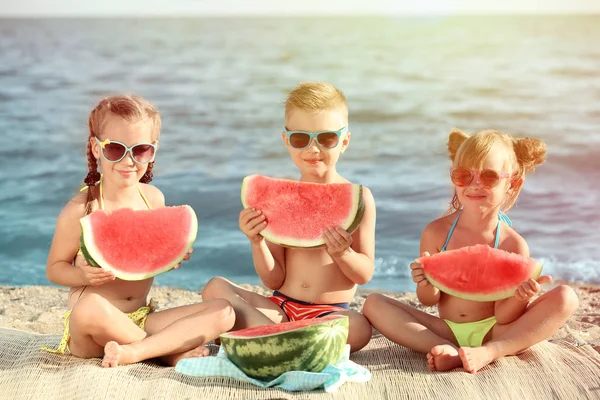 Şirin çocuk kumsalda karpuz yeme. Okul tatil kavramı