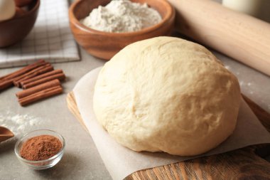 Tarçın için malzemelerle çiğ hamur rulo mutfak masasında