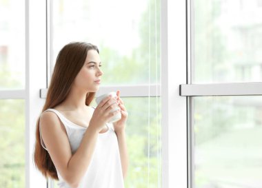 Evde kahve içen güzel bir kadın.