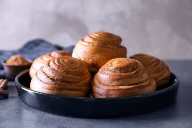 Mutfak masasının üstünde nefis tarçın ile siyah yuvarlak plaka rulo