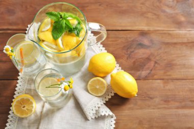 Sürahi ve bardak limon suyu ahşap masa üzerinde yenileme ile