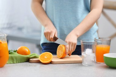 Kadın mutfakta turuncu limonata hazırlanıyor