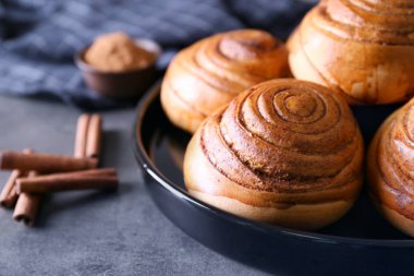 Mutfak masasının üstünde nefis tarçın ile siyah yuvarlak plaka rulo