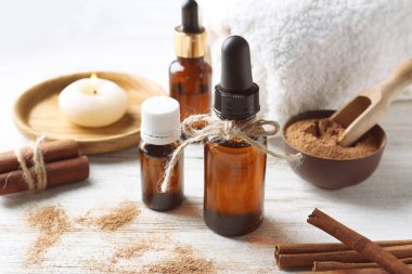 Ahşap zemin üzerine tarçın yağı şişe ile kompozisyon