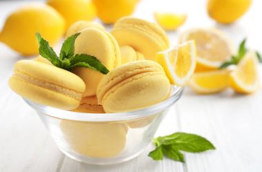 Cam kase lezzetli limon macarons üzerinde beyaz ahşap masa, closeup ile