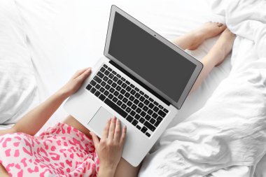 Laptop ile yatağa çalışan genç kadın