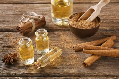 Ahşap zemin üzerine tarçın yağı şişe ile kompozisyon