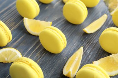 Lezzetli taze macarons ve ahşap masa, tatlı limon dilimleri